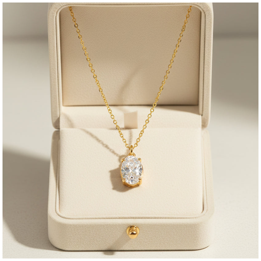 A gold chain necklace with an oval-cut clear gemstone pendant in a gold bezel setting, shown against a plain white background.