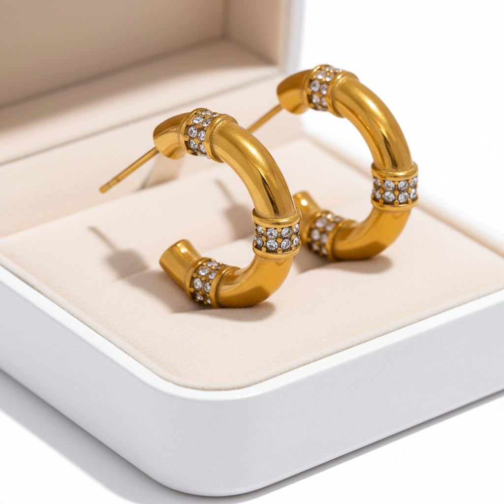Gold hoop earrings with embedded crystals on a white background