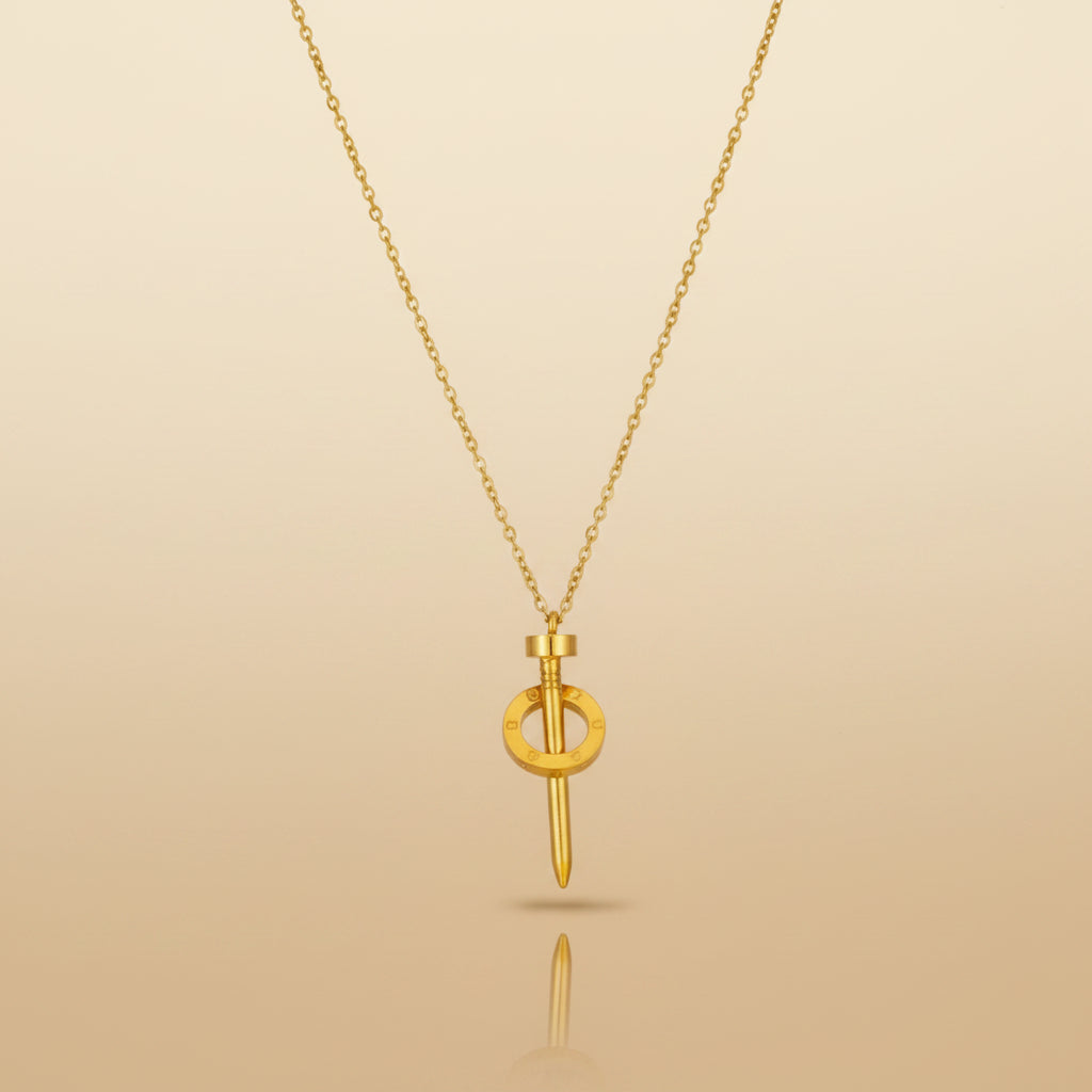 A gold pendant necklace featuring a stylized dagger or sword design with a circular ring detail, suspended from a delicate gold chain against a plain white background.